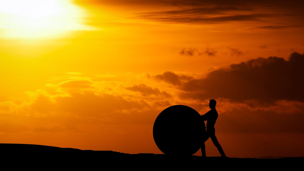 A man pushing a rock uphill